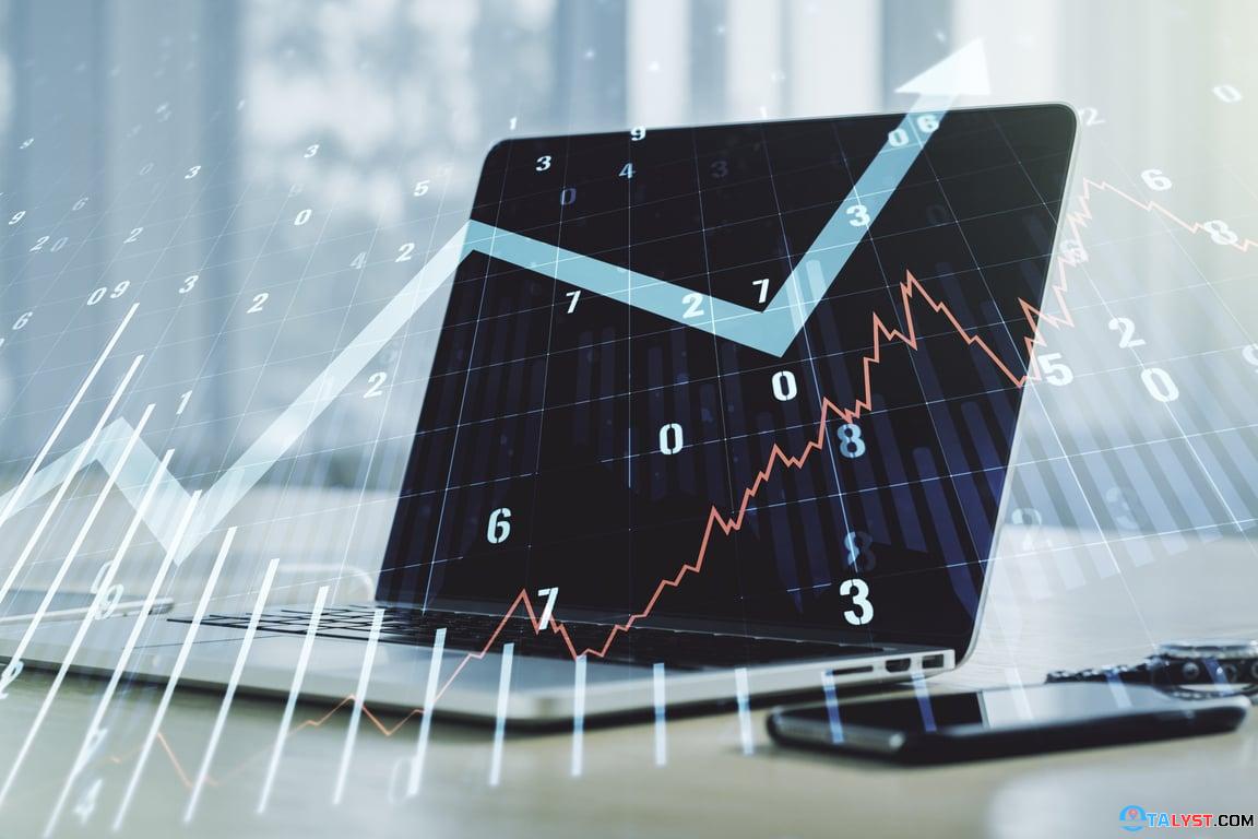 Workstation with a computer displaying charts and figures, symbolizing the continuous adjustment and review process in property forecasting”